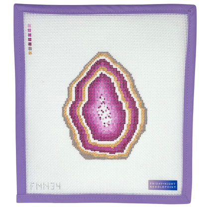 Needlepoint pink geode design on a needlepoint canvas with a purple border.