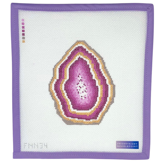 Needlepoint pink geode design on a needlepoint canvas with a purple border.