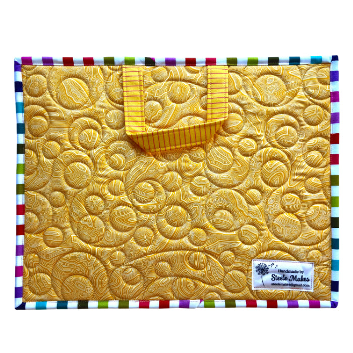 Yellow textured fabric with a colorful border and a label on a white background project bag fish bowl quilted bubbles