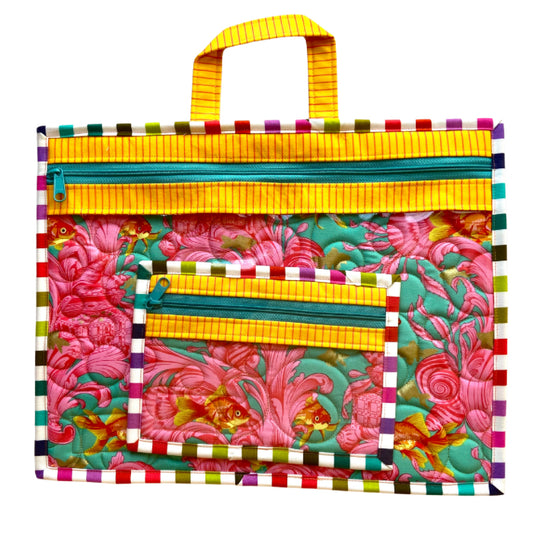 Colorful fabric pouch with floral pattern and striped handle on a white background needlepoint project bag fish bowl quilted bubbles