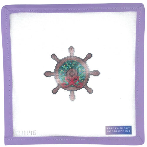 needlepoint design of a holiday wreath on a nautical ship wheel on a white fabric with a purple border, featuring a brand label at the bottom right corner.